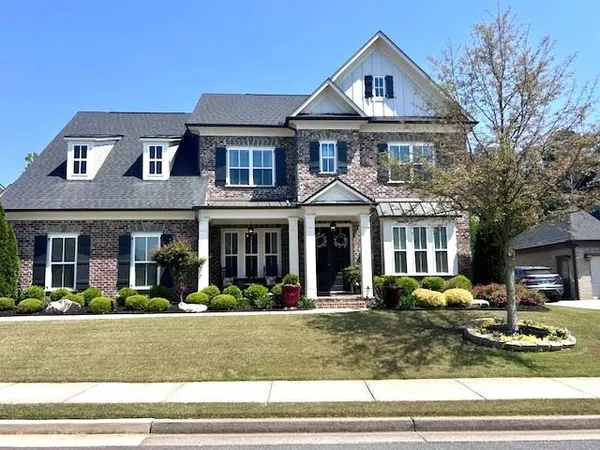 a front view of a house with garden and plants