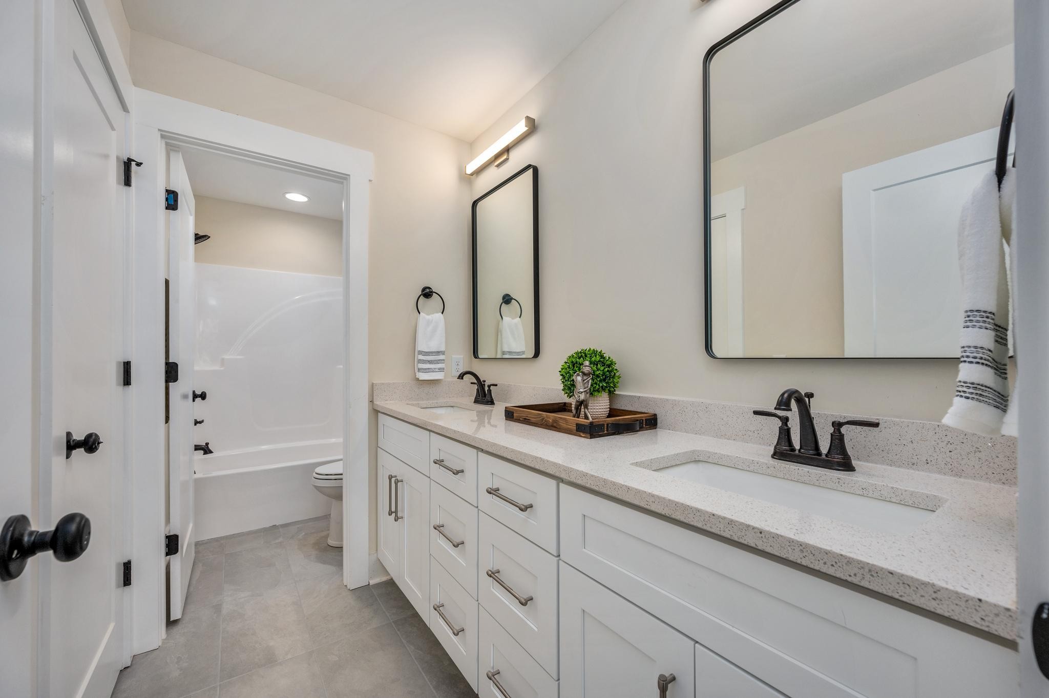 2416 Dilton Mankin Road Murfreesboro, TN 37127 - Photo 28 of 36 a bathroom with a double vanity sink a mirror and shower