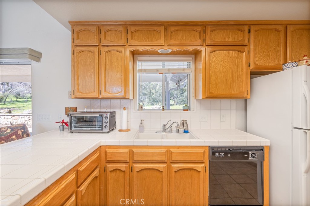 50174 Bissett Station Road Oakhurst, CA 93644 - Photo 11 of 75 a kitchen with stainless steel appliances granite countertop a sink a stove and cabinets