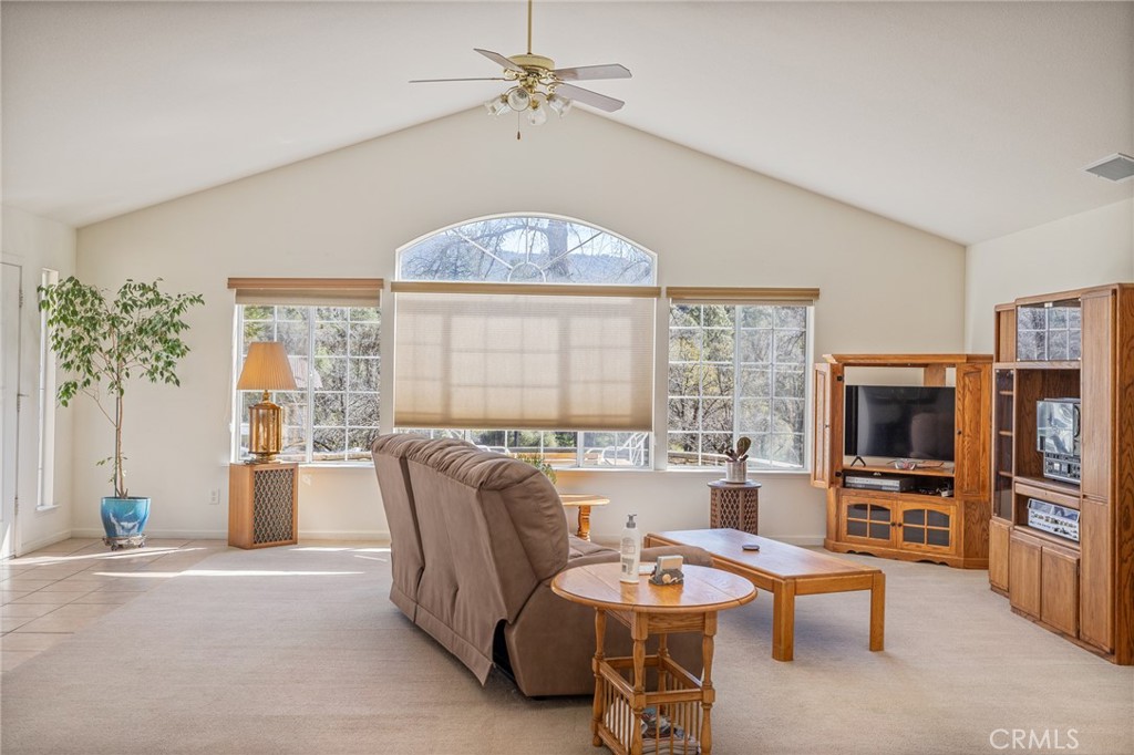 50174 Bissett Station Road Oakhurst, CA 93644 - Photo 19 of 75 a living room with furniture a flat screen tv and a floor to ceiling window