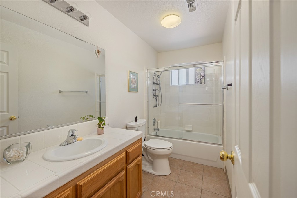 50174 Bissett Station Road Oakhurst, CA 93644 - Photo 32 of 75 a bathroom with a granite countertop sink toilet and shower