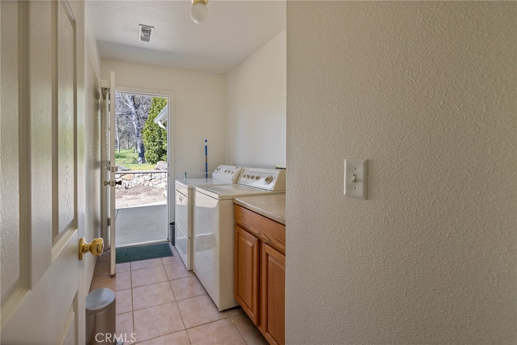 50174 Bissett Station Road Oakhurst, CA 93644 - Photo 34 of 75 a utility room with cabinets washer and dryer