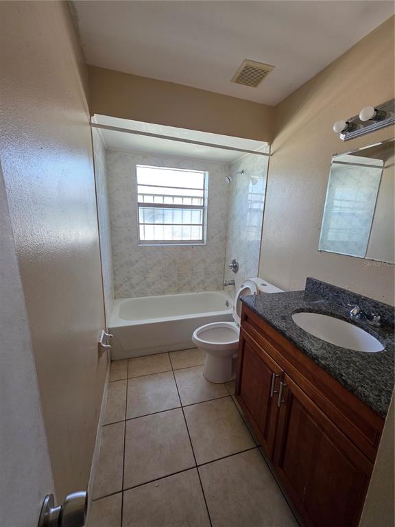 5905 Altec Road Orlando, FL 32808 - Photo 7 of 9 a bathroom with a granite countertop sink a toilet a mirror and bathtub
