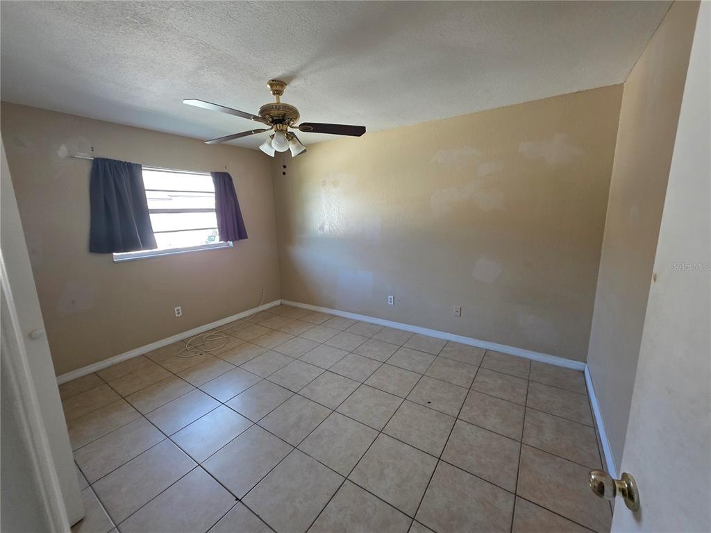 5905 Altec Road Orlando, FL 32808 - Photo 8 of 9 an empty room with windows and fan