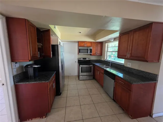 a kitchen with stainless steel appliances granite countertop a sink stove and refrigerator