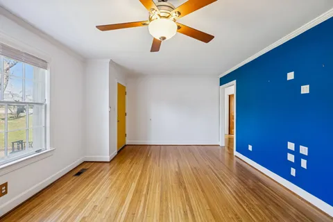 a view of empty room with window and wooden floor