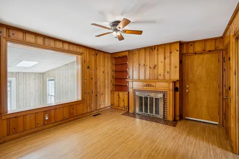 a view of an empty room with a fireplace and a window