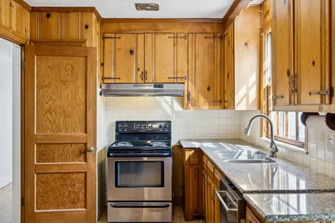a kitchen with granite countertop a sink and a refrigerator