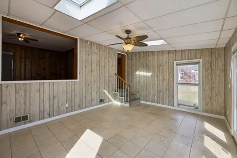 a view of a hallway with wooden floor and a ceiling fan