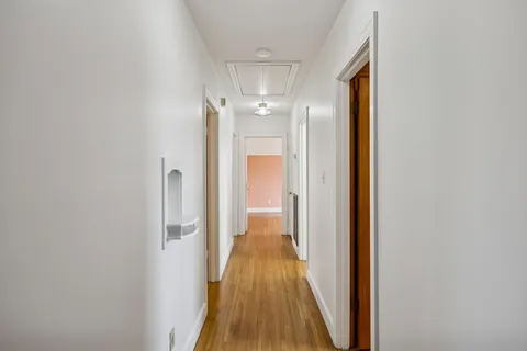 a view of a hallway with wooden floor