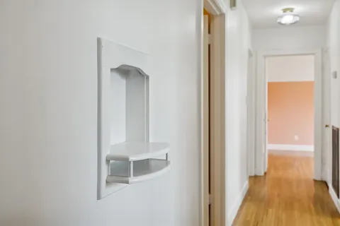 a view of a hallway with wooden floor and staircase