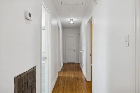a view of a hallway with wooden floor