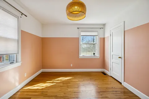 a view of a room with wooden floor and window