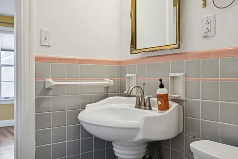 a bathroom with a toilet a sink and mirror