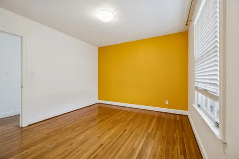 a view of empty room with wooden floor