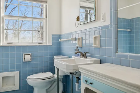 a bathroom with a sink a toilet and a mirror