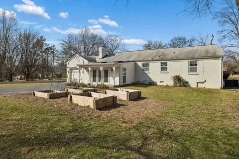 a front view of a house with garden and sitting area
