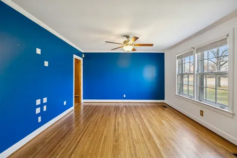 a view of a livingroom with a window and wooden floor
