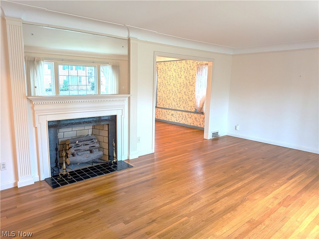 2316 Glendon Road Cleveland, OH 44118 - Photo 4 of 22 Unfurnished living room featuring wood finished floors, a fireplace, and crown molding