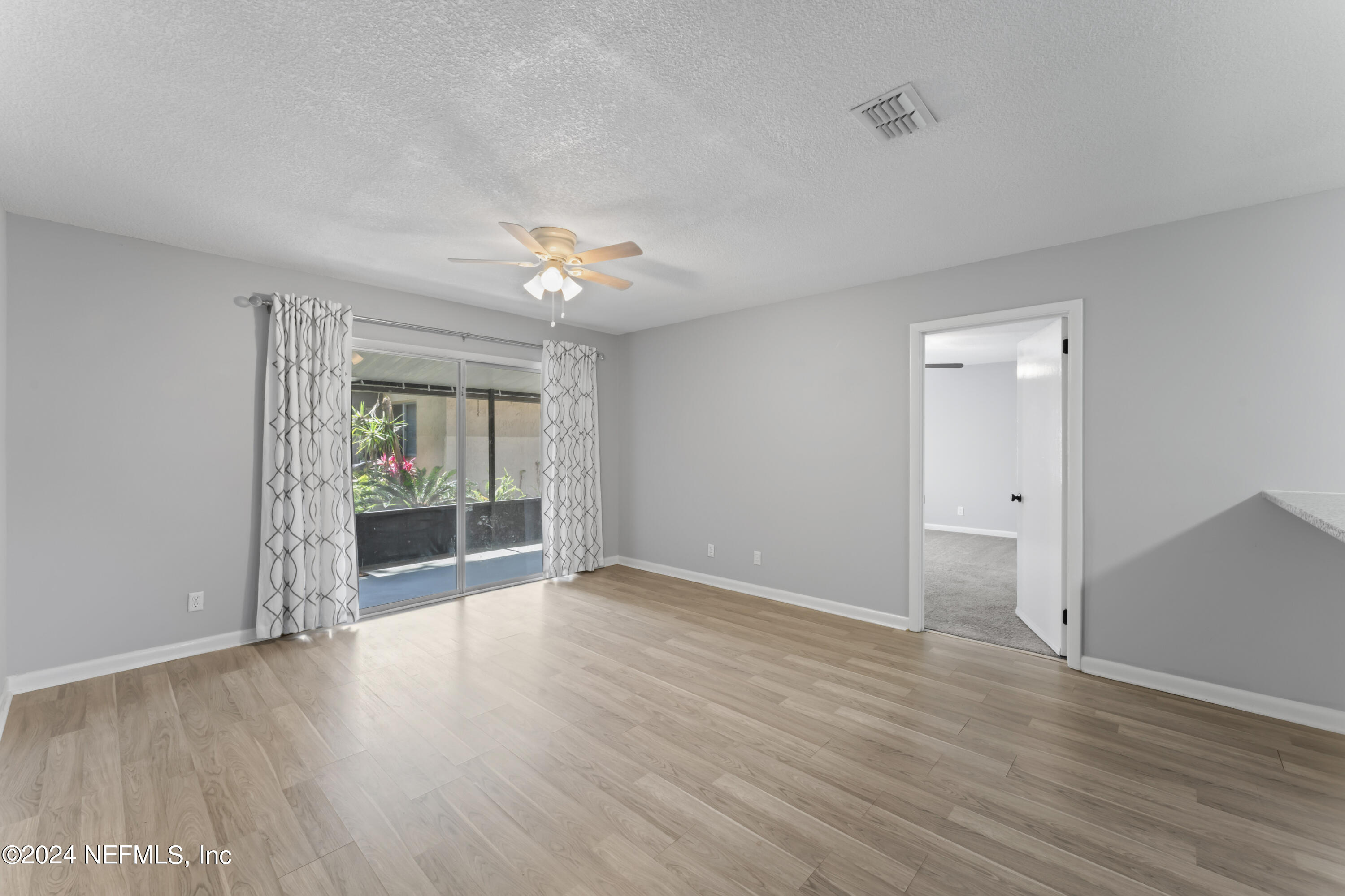 1283 The Grove Road Orange Park, FL 32073 - Photo 15 of 49 a view of an empty room with wooden floor and a window