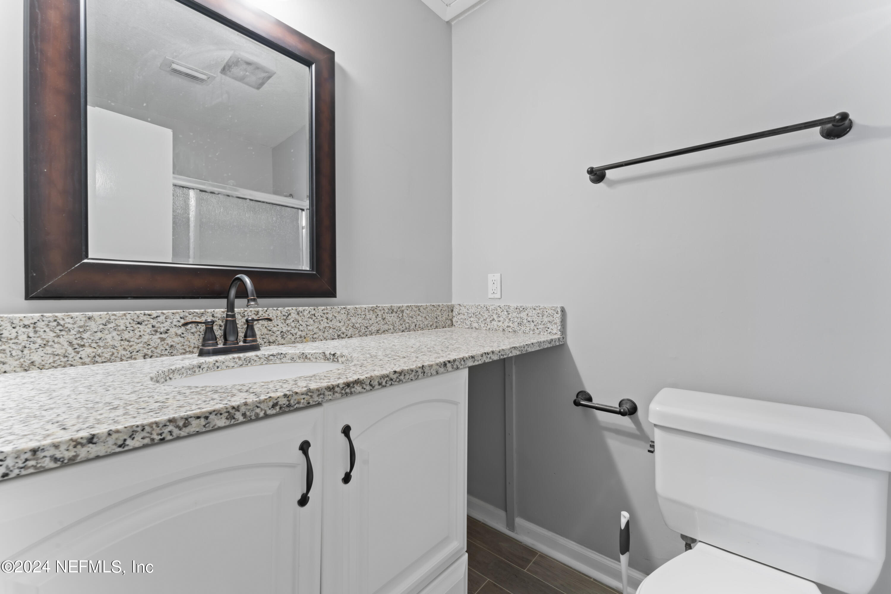 1283 The Grove Road Orange Park, FL 32073 - Photo 19 of 49 a bathroom with a granite countertop sink a toilet and a mirror