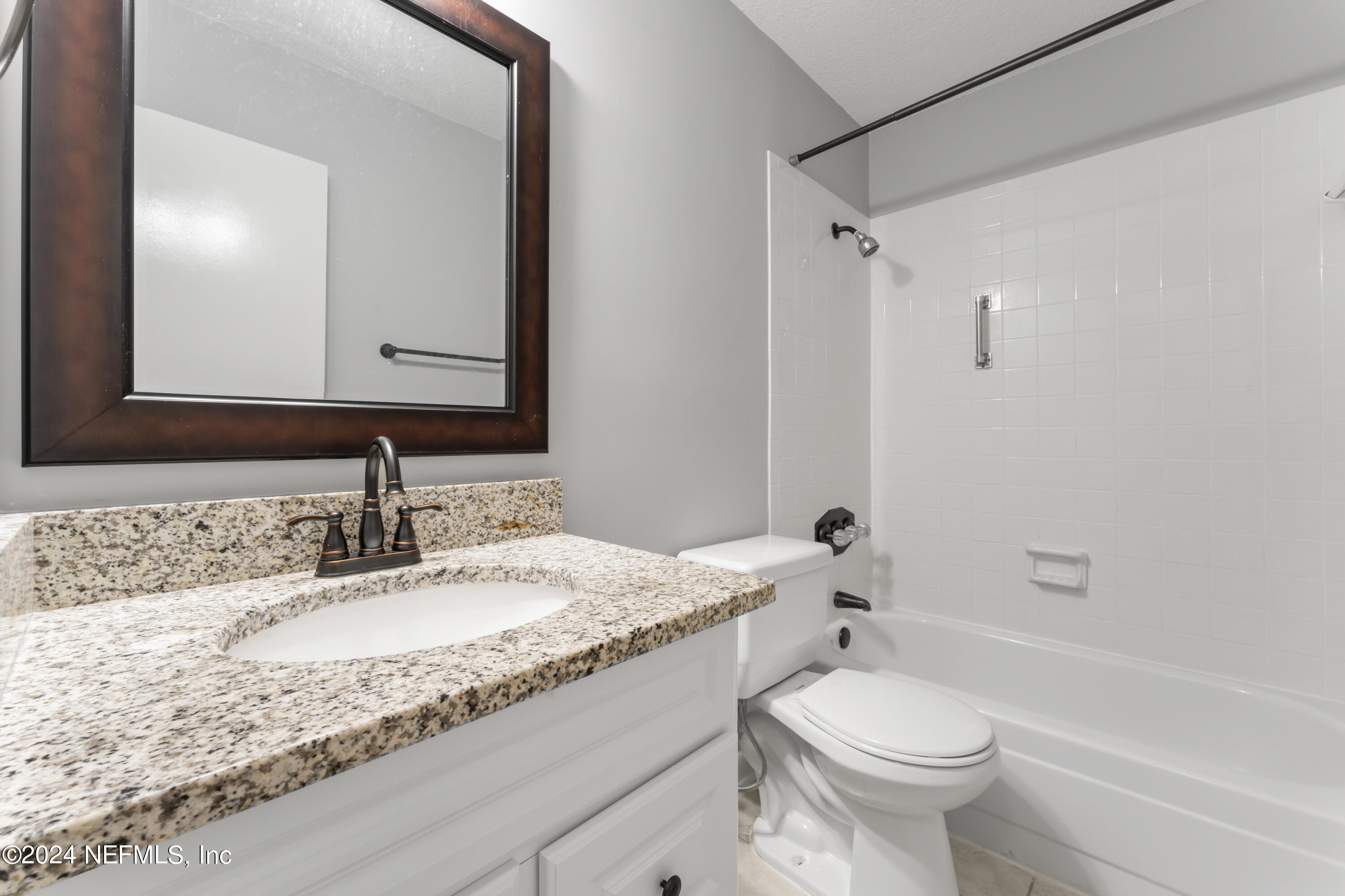 1283 The Grove Road Orange Park, FL 32073 - Photo 26 of 49 a bathroom with a granite countertop sink toilet mirror and bathtub