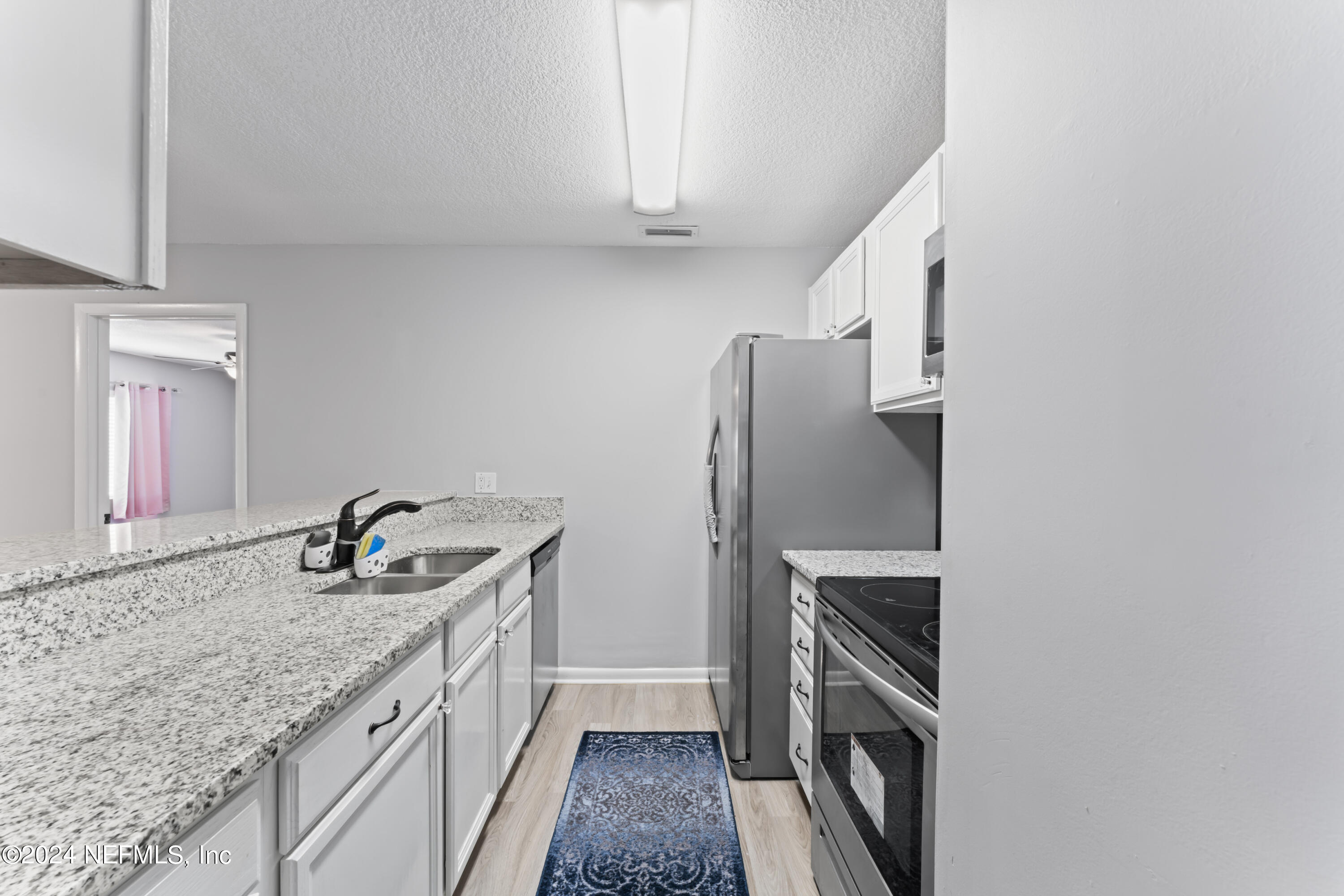 1283 The Grove Road Orange Park, FL 32073 - Photo 9 of 49 a kitchen with stainless steel appliances granite countertop a sink stove and refrigerator