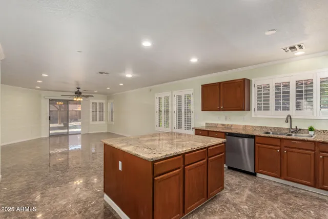 a kitchen with stainless steel appliances granite countertop a sink a stove a microwave a refrigerator and cabinets