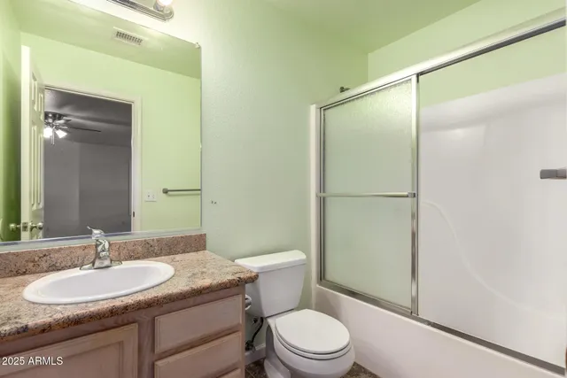 a view of a livingroom with a fan a ceiling fan and window
