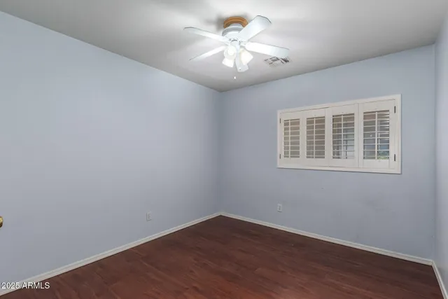 a view of a big room with wooden floor and windows