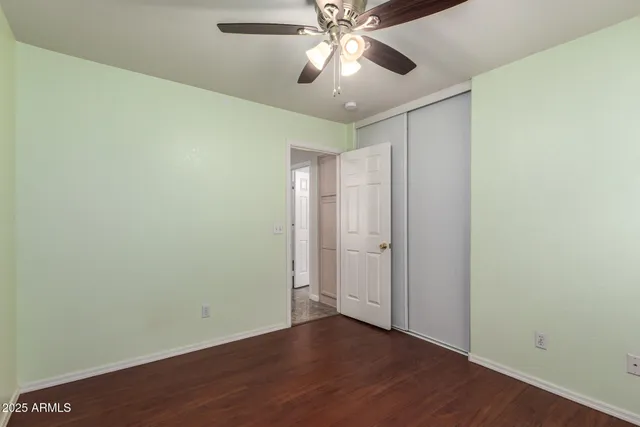 an empty room with wooden floor a ceiling fan and wooden floor