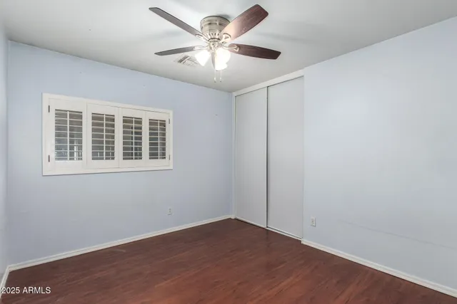 a bathroom with a granite countertop sink a toilet a mirror and shower
