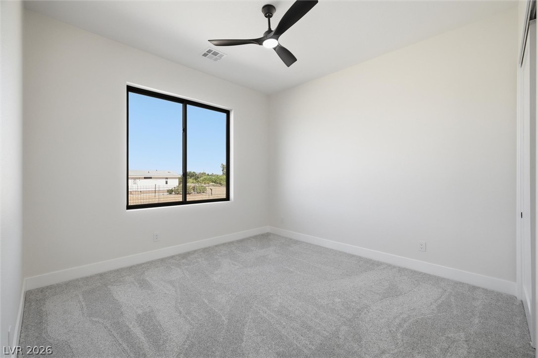 5910 East Kellogg Road Pahrump, NV 89061 - Photo 28 of 58 A spacious room with a modern ceiling fan offers abundant natural light through a generous window.