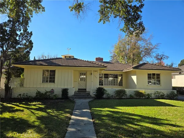 a front view of a house with a garden