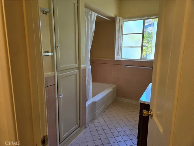 a bathroom with a window a bathtub and a shower
