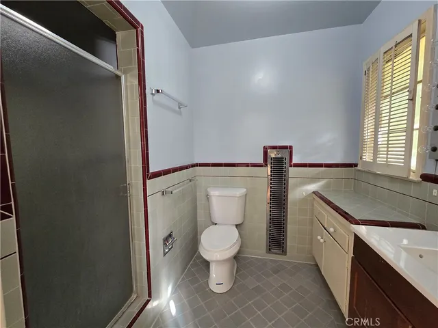 a bathroom with a granite countertop toilet and a sink