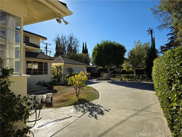 a view of a patio with table and chairs potted plants and a palm tree