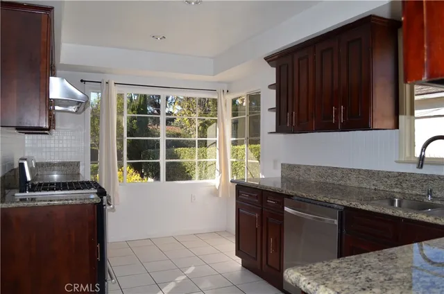 a kitchen with granite countertop a sink a stove and a microwave