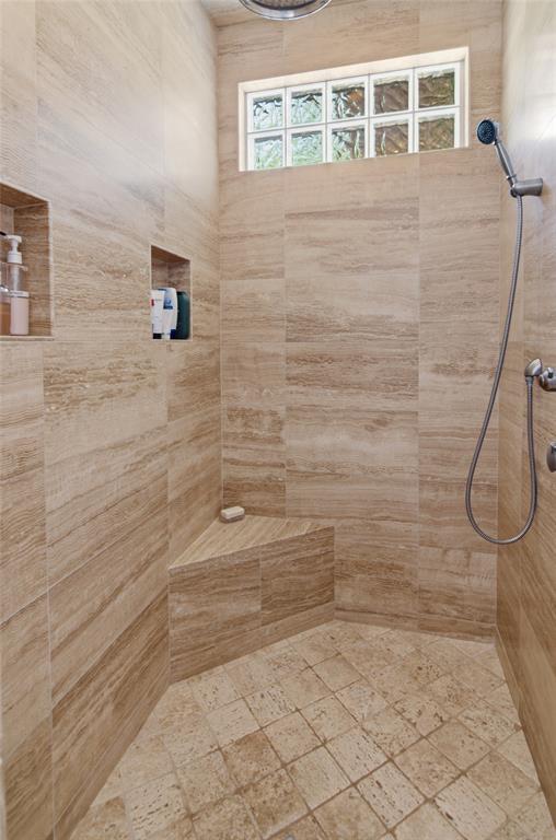 1138 Bancroft Road Keller, TX 76248 - Photo 20 of 39 Tiled shower with a rainfall showerhead, handheld shower fixture, and a built-in corner bench