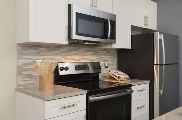 a kitchen with granite countertop cabinets stainless steel appliances and a counter space