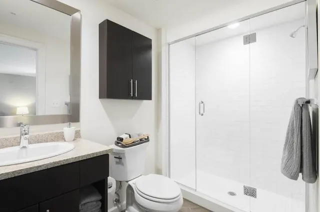 a bathroom with a sink a toilet and shower