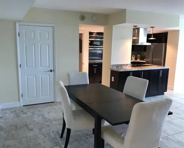 a living room with furniture a flat screen tv and kitchen view