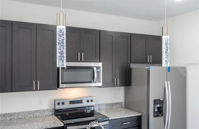 a kitchen with stainless steel appliances granite countertop a refrigerator and a stove