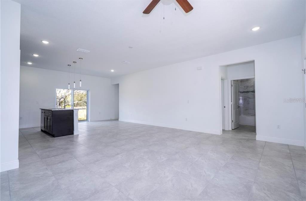 9809 North Swanee Terrace Citrus Springs, FL 34433 - Photo 22 of 46 an empty room with kitchen view and a hallway