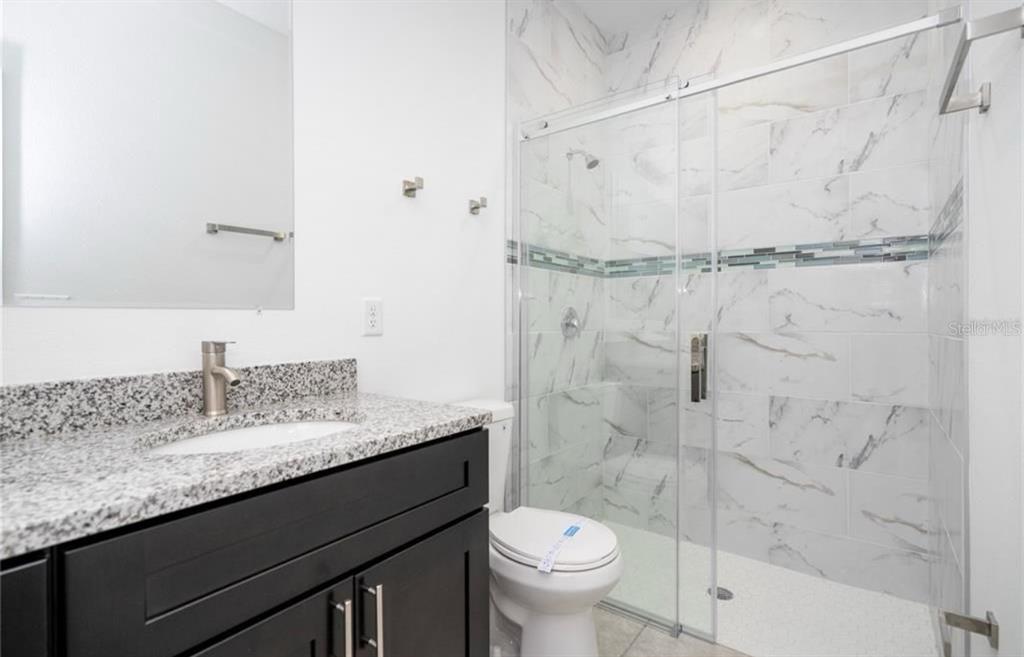 9809 North Swanee Terrace Citrus Springs, FL 34433 - Photo 30 of 46 a bathroom with a granite countertop sink a toilet and shower