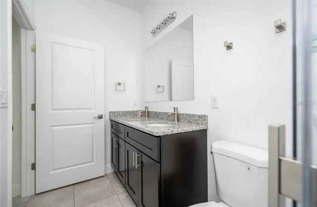 a bathroom with a granite countertop sink and a mirror