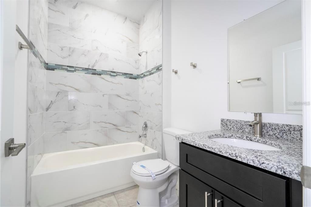 9809 North Swanee Terrace Citrus Springs, FL 34433 - Photo 35 of 46 a bathroom with a granite countertop sink toilet and shower