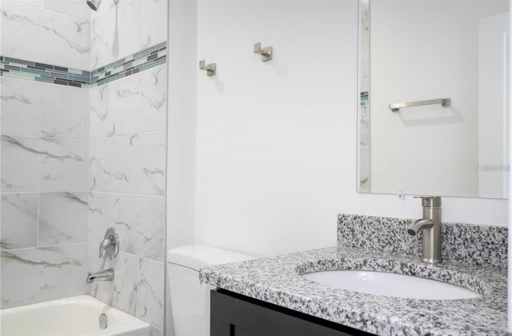 9809 North Swanee Terrace Citrus Springs, FL 34433 - Photo 36 of 46 a bathroom with a granite countertop sink a mirror and shower