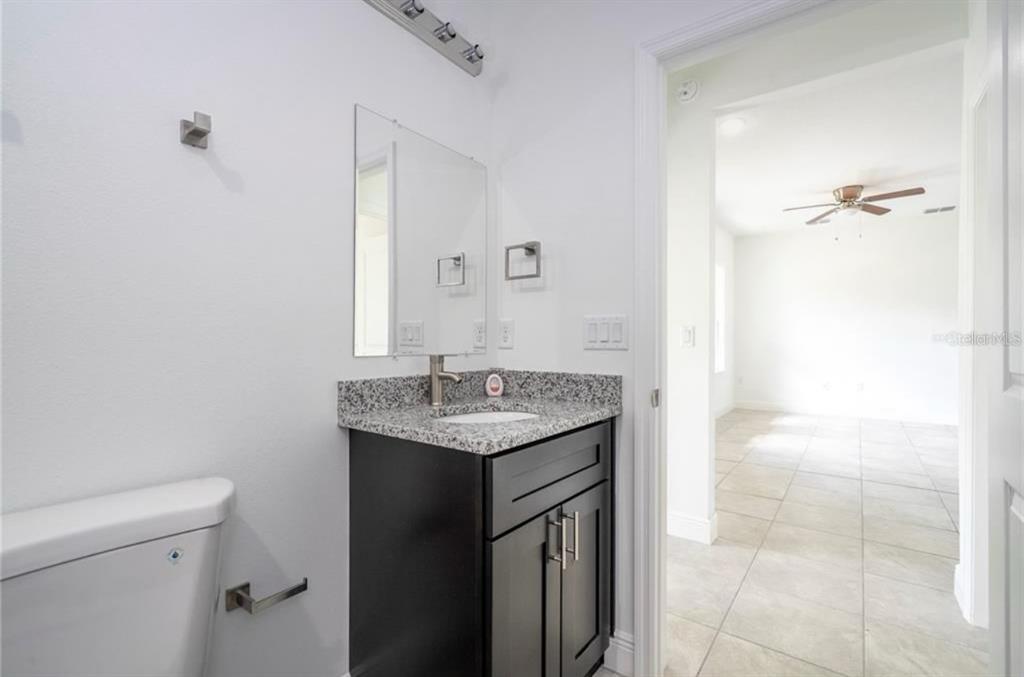 9809 North Swanee Terrace Citrus Springs, FL 34433 - Photo 38 of 46 a bathroom with a granite countertop sink a toilet and a mirror