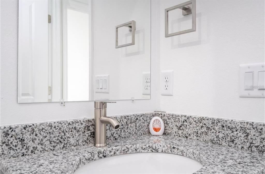 9809 North Swanee Terrace Citrus Springs, FL 34433 - Photo 39 of 46 a bathroom with a granite countertop sink a mirror and shower